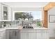 Bright kitchen featuring white cabinets, subway tile backsplash, quartz countertops, and a large window at 3499 43Rd N St, St Petersburg, FL 33713