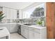 Bright kitchen featuring white cabinets, subway tile backsplash, quartz countertops, and a large window at 3499 43Rd N St, St Petersburg, FL 33713