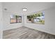 Well-lit bedroom with grey wood-look flooring and large windows at 3547 Garfield Dr, Holiday, FL 34691