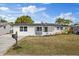 Newly renovated home with white brick exterior, landscaped lawn, and a covered porch at 3547 Garfield Dr, Holiday, FL 34691