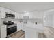 White kitchen with quartz countertops and stainless steel appliances at 3547 Garfield Dr, Holiday, FL 34691