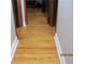 Hallway with beautiful stained wood floors and white baseboards at 3829 Biscay Pl, Land O Lakes, FL 34639