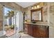 Beautiful bathroom featuring stone walls, a statement sink, and a view of the backyard at 3903 Sand Dollar Pl, Tampa, FL 33634