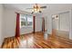 Bright bedroom featuring hardwood floors, ceiling fan, window with curtains, and mirrored sliding closet doors at 3903 Sand Dollar Pl, Tampa, FL 33634