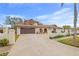 Home's front exterior with a paver driveway, manicured landscape, and a brown garage door at 3903 Sand Dollar Pl, Tampa, FL 33634