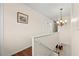 Upstairs hallway featuring a decorative chandelier and wood and tile flooring at 3903 Sand Dollar Pl, Tampa, FL 33634