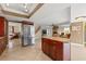 Open kitchen featuring stainless steel appliances, granite countertops, a center island, and travertine tile flooring at 3903 Sand Dollar Pl, Tampa, FL 33634