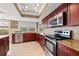 Kitchen with stainless steel appliances, granite countertops, dark wood cabinets, and tile backsplash at 3903 Sand Dollar Pl, Tampa, FL 33634