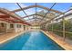 Outdoor pool with screened enclosure, tiled deck, and partial view of the home's exterior at 3903 Sand Dollar Pl, Tampa, FL 33634