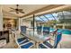 Covered patio boasts a spacious dining and seating area next to the pool at 393 Waterford E Cir, Tarpon Springs, FL 34688