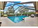 Inviting screened-in pool featuring a sun shelf and clear blue water at 393 Waterford E Cir, Tarpon Springs, FL 34688