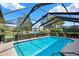 Screened-in pool area with a refreshing pool and views of the lake at 393 Waterford E Cir, Tarpon Springs, FL 34688