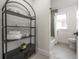 Bright bathroom with black shelving, white bathtub, and green tile shower at 409 E Adalee St, Tampa, FL 33603