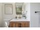 Stylish bathroom featuring a wood vanity, white countertop, and a curved mirror at 409 E Adalee St, Tampa, FL 33603