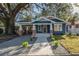 Renovated blue house with a walkway, landscaping, and a spacious front yard at 409 E Adalee St, Tampa, FL 33603