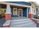 Renovated front porch with new flooring, brick columns, and a wood door at 409 E Adalee St, Tampa, FL 33603