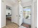 Bright entry showcasing tile floors, a storm door, and a view into a bedroom at 4210 Revere Cir, New Port Richey, FL 34653