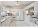 Bright kitchen with white cabinets, tile flooring, and ample counter space for cooking at 4210 Revere Cir, New Port Richey, FL 34653