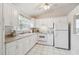 White kitchen featuring ample counter space, natural light, and views of the backyard at 4210 Revere Cir, New Port Richey, FL 34653