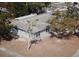 Aerial view of a well-maintained single-story home with an in-ground pool, mature trees and lawn at 4645 Commodore Ave, Spring Hill, FL 34606