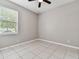 Bright bedroom with window, ceiling fan and tile floor at 5200 Suncatcher Dr, Wesley Chapel, FL 33545