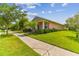 Side view of a charming one-story house with a peach-colored exterior and lush landscaping at 5200 Suncatcher Dr, Wesley Chapel, FL 33545