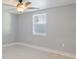 This bedroom has tile flooring, a ceiling fan, and a bright window at 5864 Mckee Lake N Dr, St Petersburg, FL 33709