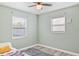 Bedroom features a ceiling fan, laminate floors and two windows at 5864 Mckee Lake N Dr, St Petersburg, FL 33709