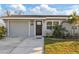 Close-up of a well-maintained house featuring a welcoming front door with stylish signage and manicured landscaping at 5864 Mckee Lake N Dr, St Petersburg, FL 33709