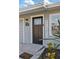 Close-up of the front door with a welcome sign and modern design with a storm door at 5864 Mckee Lake N Dr, St Petersburg, FL 33709