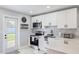 Bright kitchen featuring white cabinets, stainless steel appliances, and a door leading to the outside at 5864 Mckee Lake N Dr, St Petersburg, FL 33709