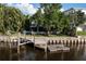 Waterfront property featuring a private boat dock, screened porch, and lush foliage at 664 Geneva Pl, Tampa, FL 33606