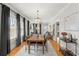 Dining area featuring a large wooden table, hardwood floors, and an open view into the living room at 705 W Kentucky Ave, Tampa, FL 33603