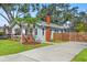 Home showcasing a well-kept lawn, concrete driveway, brick chimney, and a privacy fence at 705 W Kentucky Ave, Tampa, FL 33603