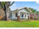 Quaint bungalow with blue door, flower boxes, brick porch columns, and a lush, green lawn at 705 W Kentucky Ave, Tampa, FL 33603