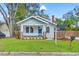 Charming bungalow featuring a cozy porch, light blue exterior, brick accents, and a well-manicured front yard at 705 W Kentucky Ave, Tampa, FL 33603