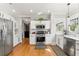 Well-lit kitchen featuring stainless steel appliances, white cabinetry, and marble countertops at 705 W Kentucky Ave, Tampa, FL 33603