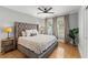 Spacious main bedroom with a large upholstered headboard and hardwood floors at 705 W Kentucky Ave, Tampa, FL 33603