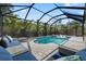 Inviting screened-in pool area with sun loungers, patio seating, and lush tropical landscaping at 705 W Kentucky Ave, Tampa, FL 33603