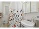 Clean bathroom with floral shower curtain and white sink at 834 11Th N St, St Petersburg, FL 33705