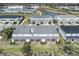 Aerial view of the back of two-story townhomes with screened-in patios, green lawns and a nearby community pond at 8463 Canyon Creek Trl, Parrish, FL 34219