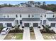 Aerial view of two-story townhomes showcasing attached garages, landscaped lawns, and well-maintained driveways at 8463 Canyon Creek Trl, Parrish, FL 34219