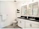 Modern bathroom featuring double sinks with black countertops and contemporary fixtures at 8463 Canyon Creek Trl, Parrish, FL 34219