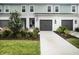 Charming two-story townhome showcasing a well-manicured lawn, gray garage doors, and tasteful landscaping at 8463 Canyon Creek Trl, Parrish, FL 34219