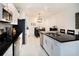 Modern kitchen featuring black countertops, stainless steel appliances, and a view to dining area at 8463 Canyon Creek Trl, Parrish, FL 34219