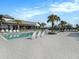 Community pool with lounge chairs and palm trees on a sunny day at 8463 Canyon Creek Trl, Parrish, FL 34219