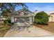 Two-car garage and front yard view of a single-story home at 9287 New Orleans Dr, Weeki Wachee, FL 34613