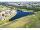 An aerial view of a home beside a pond, with golf course and neighborhood views at 970 Pembroke Point Way, Sun City Center, FL 33573