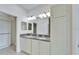 Bathroom featuring double sinks with granite countertops, white cabinets, and a walk-in closet at 970 Pembroke Point Way, Sun City Center, FL 33573