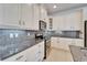 Modern kitchen featuring white cabinets, granite countertops, and stainless steel appliances for an elegant aesthetic at 970 Pembroke Point Way, Sun City Center, FL 33573